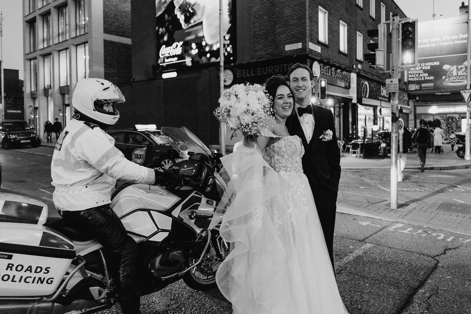 A black and white wedding photo with a police motorcycle officer in the urban street scene. Wedding PHOTOGRAPHER Dublin