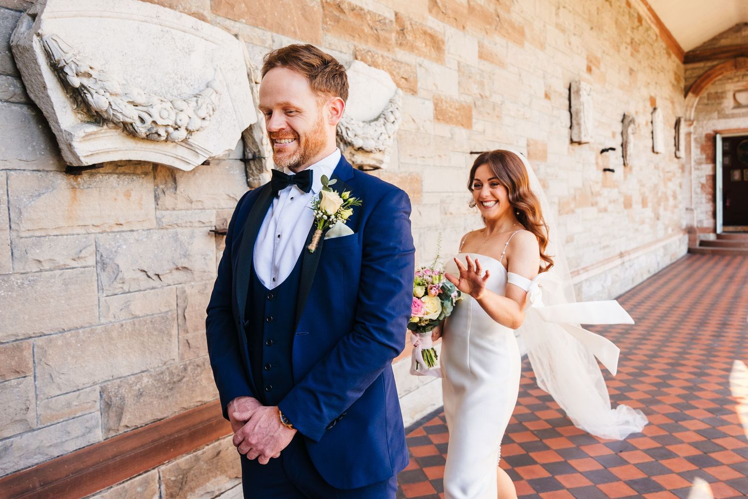 Castle Leslie Wedding Photographer Dublin First look wedding moment in a stone hallway with decorative architecture.