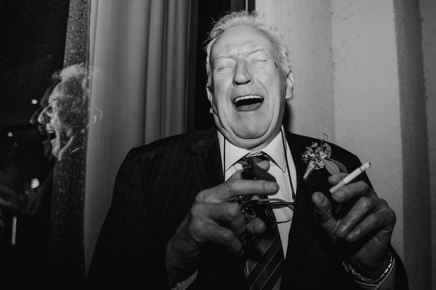 Black and white candid portrait of guest laughing heartily at wedding reception.Wedding Photography Trim Castle Ireland