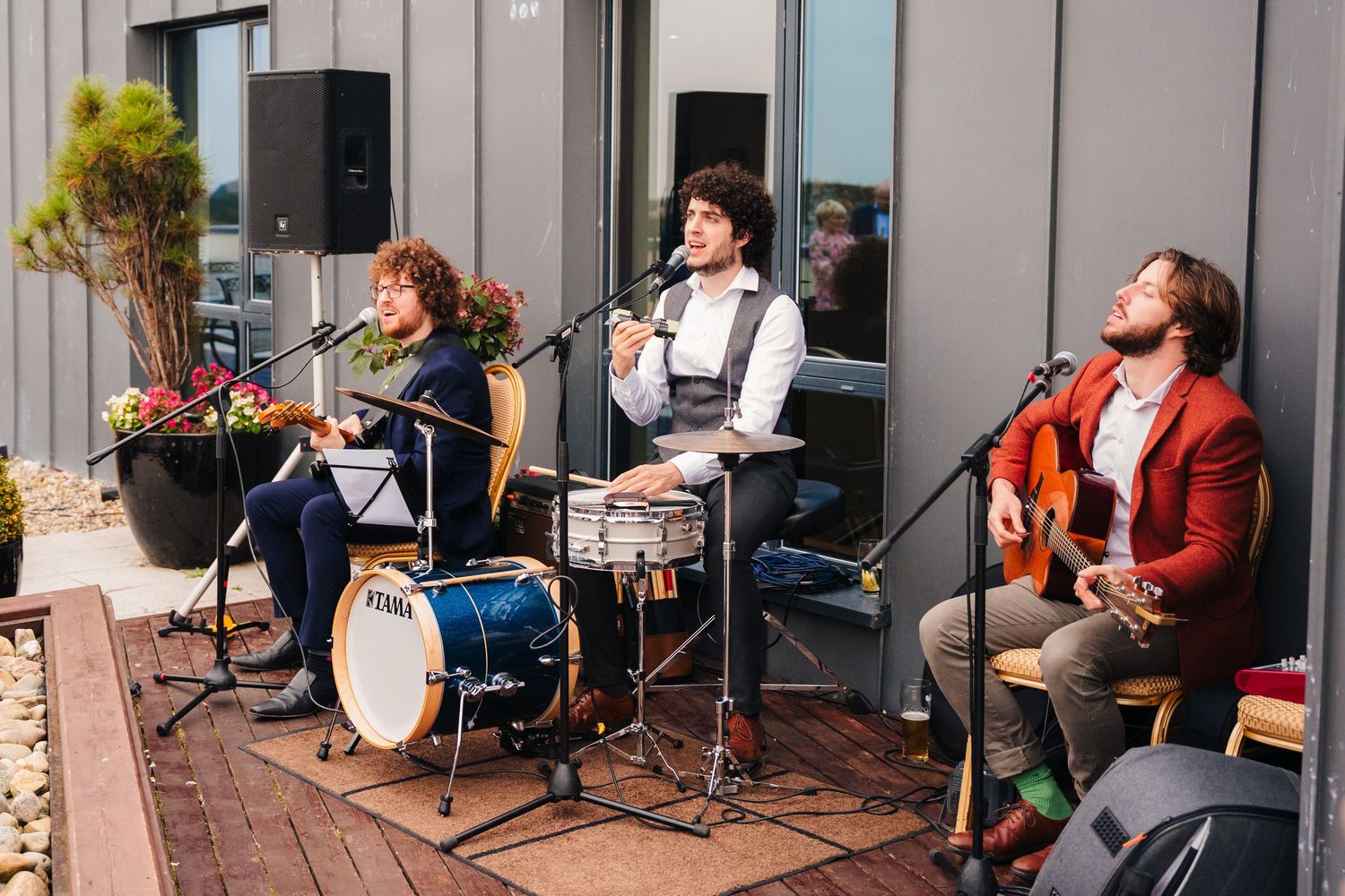 Musicians perform on outdoor patio with instruments and microphones during daytime event.Wedding Photography Trim Castle Ireland