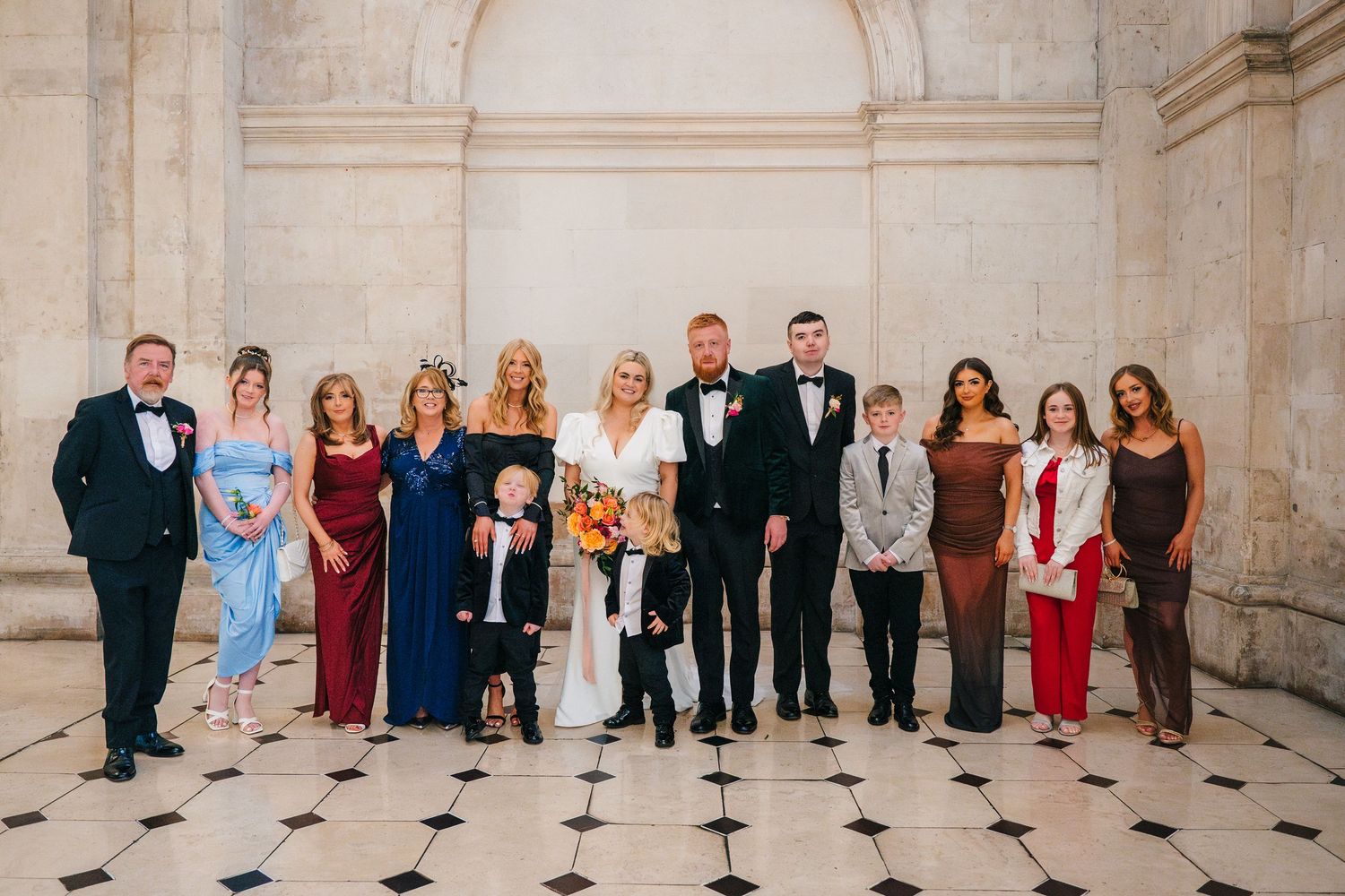 Wedding party group photo lined up in formal attire against a classic architectural backdrop. Wedding photographer dublin