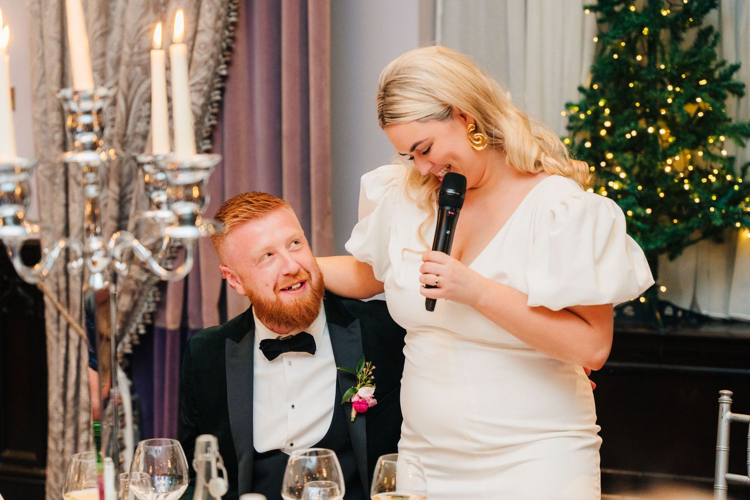 Festive wedding reception scene with Christmas trees and elegant decor in background. Wedding photographer dublin