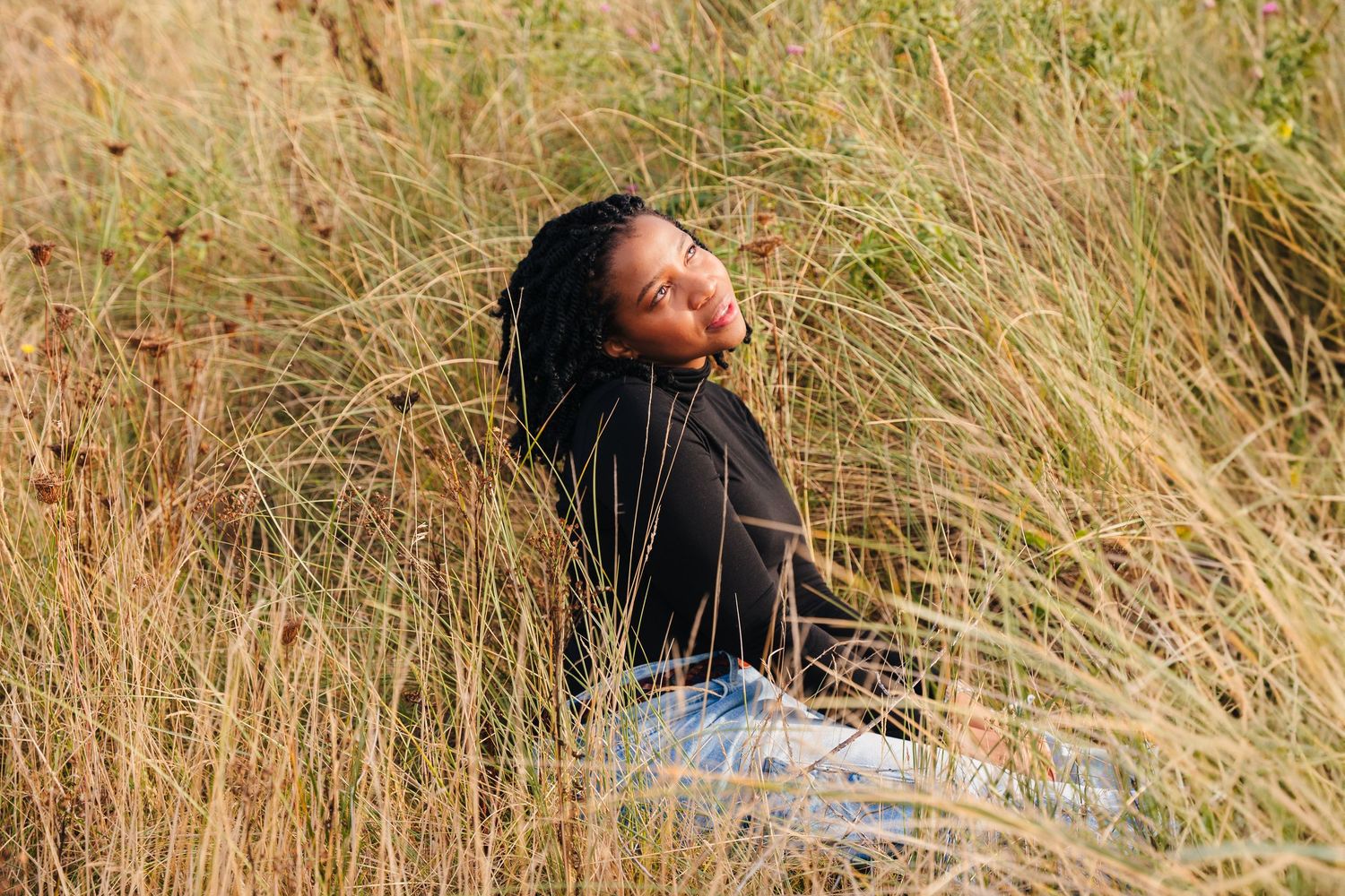 Person relaxing in tall grass field on a sunny afternoon. Dublin professional headshots photographer