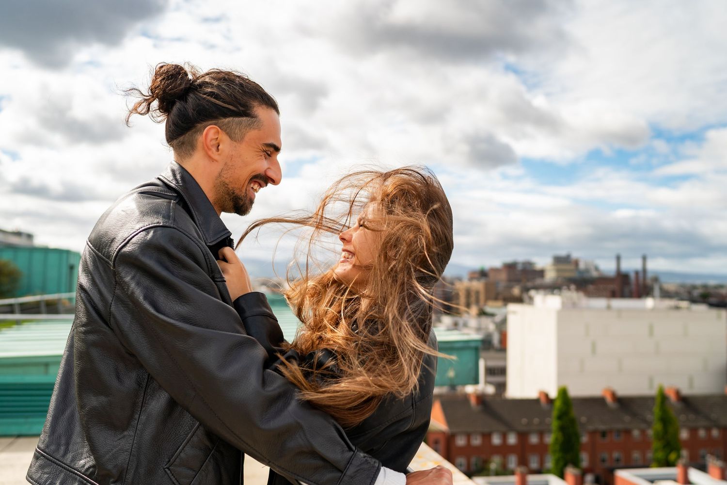 Playful rooftop dance scene with downtown buildings visible in background. Couple's Photoshoot PHOTOGRAPHER Dublin