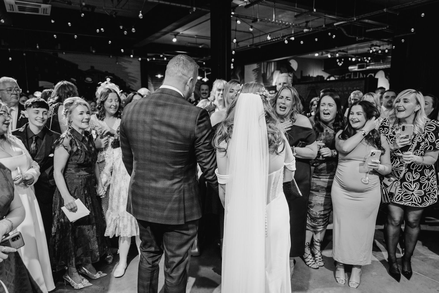 A black and white photo montage of wedding reception moments showing guests dancing and celebrating on the dance floor. Dublin wedding photo