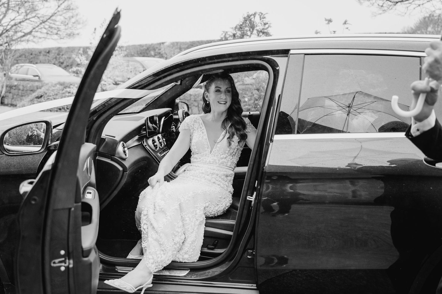 Black and white photo sequence of a bride getting into a classic car on her wedding day.