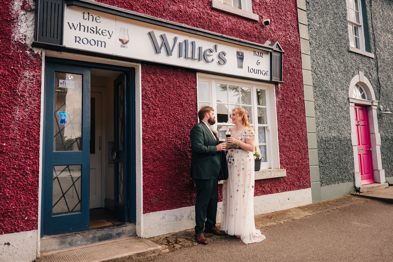 Exterior view of Willie's Inn with red painted walls and grey stone accents. . Village Barn Tyrrellspass wedding photographer Ireland