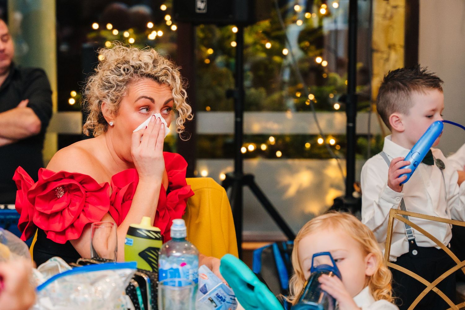 Children enjoying snacks and drinks at a festive party with twinkling lights in background.  Wedding PHOTOGRAPHER Trim Castle
