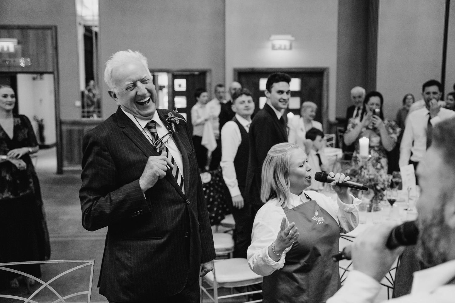 Black and white photo of wedding guests laughing and celebrating at a reception.Wedding Photography Trim Castle Ireland