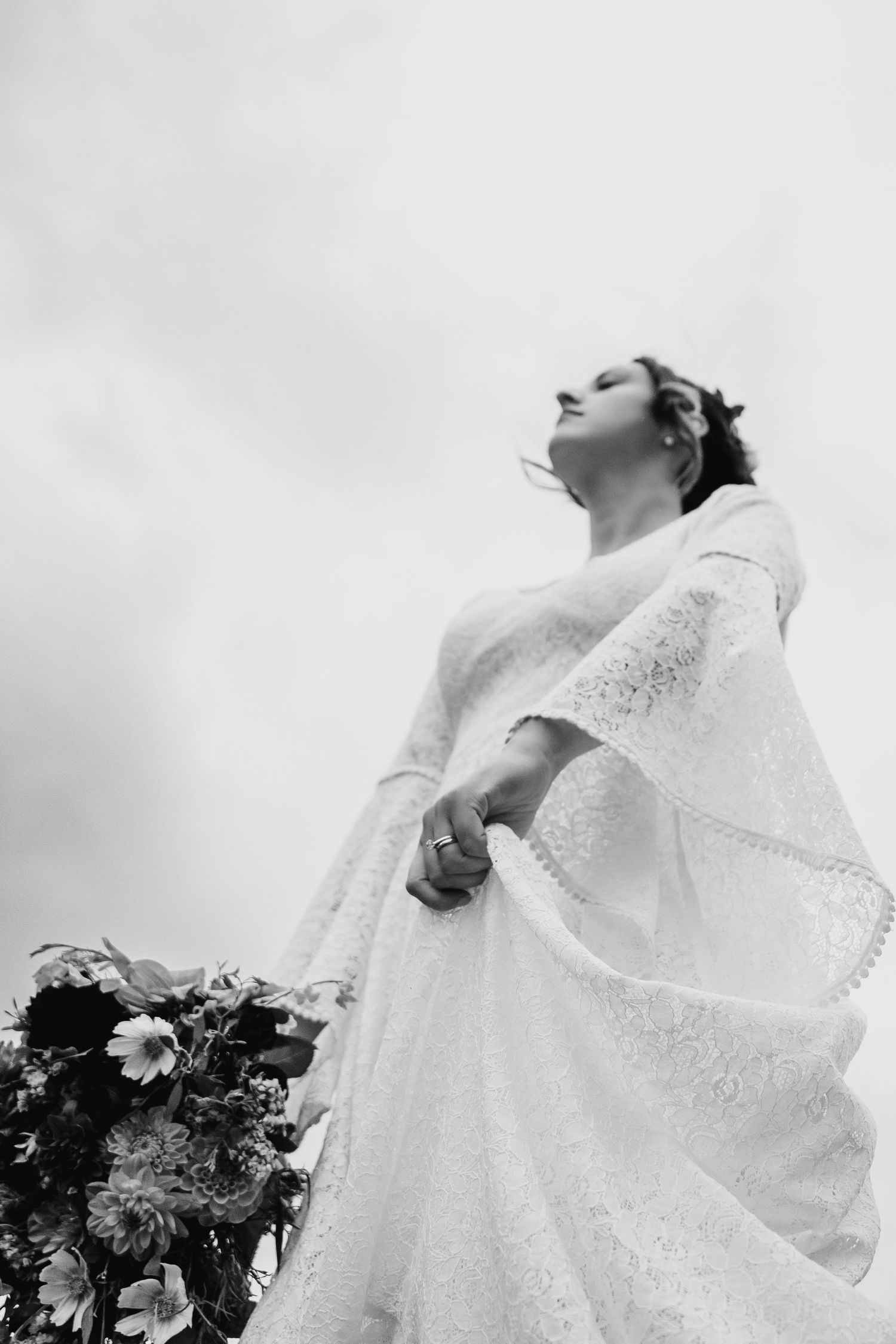Dramatic black and white photo of a bride in a lace wedding dress looking skyward with ethereal lighting. Wedding Photography Trim Castle Ir