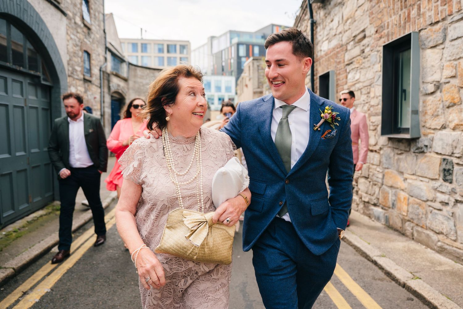 Two people walking and laughing together down a stone alley. Same sex wedding PHOTOGRAPHER Dublin