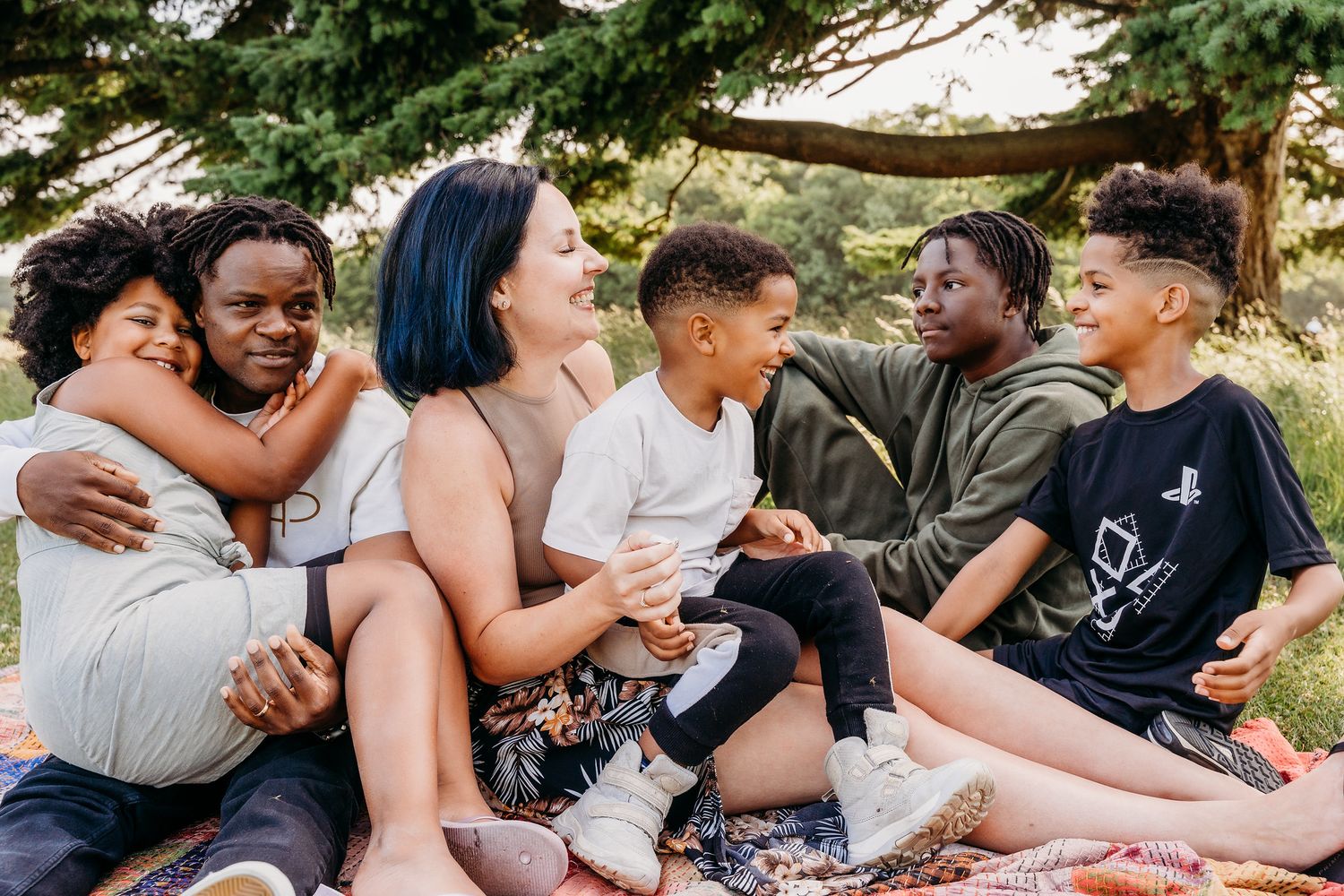 Diverse group of friends sitting together outdoors and sharing laughs on a sunny day. family PHOTOGRAPHER Dublin