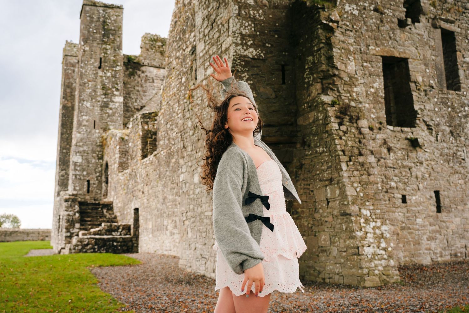 Series of photos showing a person in a white dress posing against an ancient stone castle wall. BEctive abbey family photographer dublin