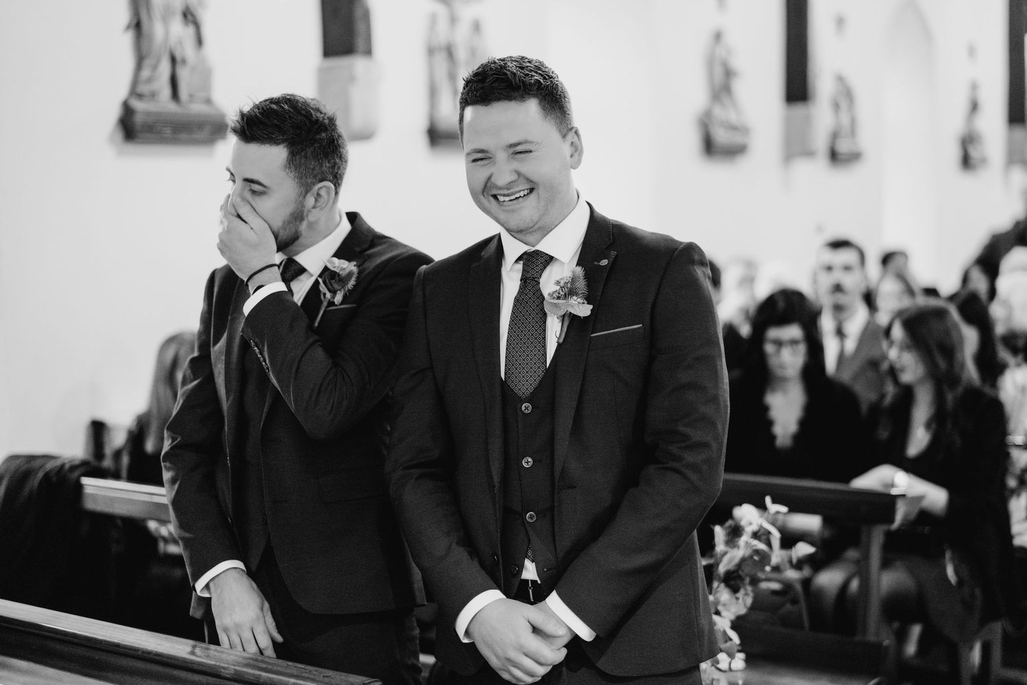 Wedding guests share emotional moments during an indoor ceremony.