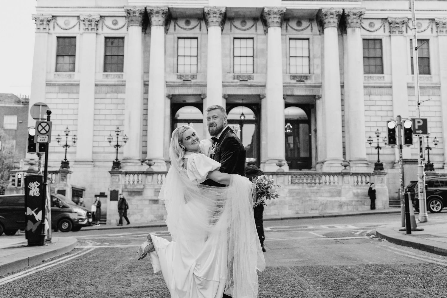 Wedding party poses for photos outside a historic government building with classical architecture. City Hall Dublin Photographer