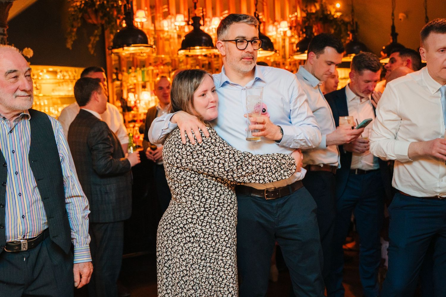Wedding reception guests dancing and mingling in an elegant ballroom with warm lighting and draping. Marco Pierre Dublin Wedding Photographe