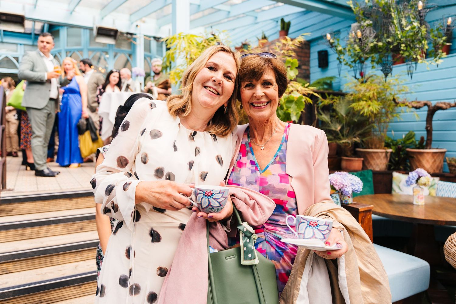 Two friends in casual attire share a moment at an outdoor social gathering. House Dublin Wedding Photographer