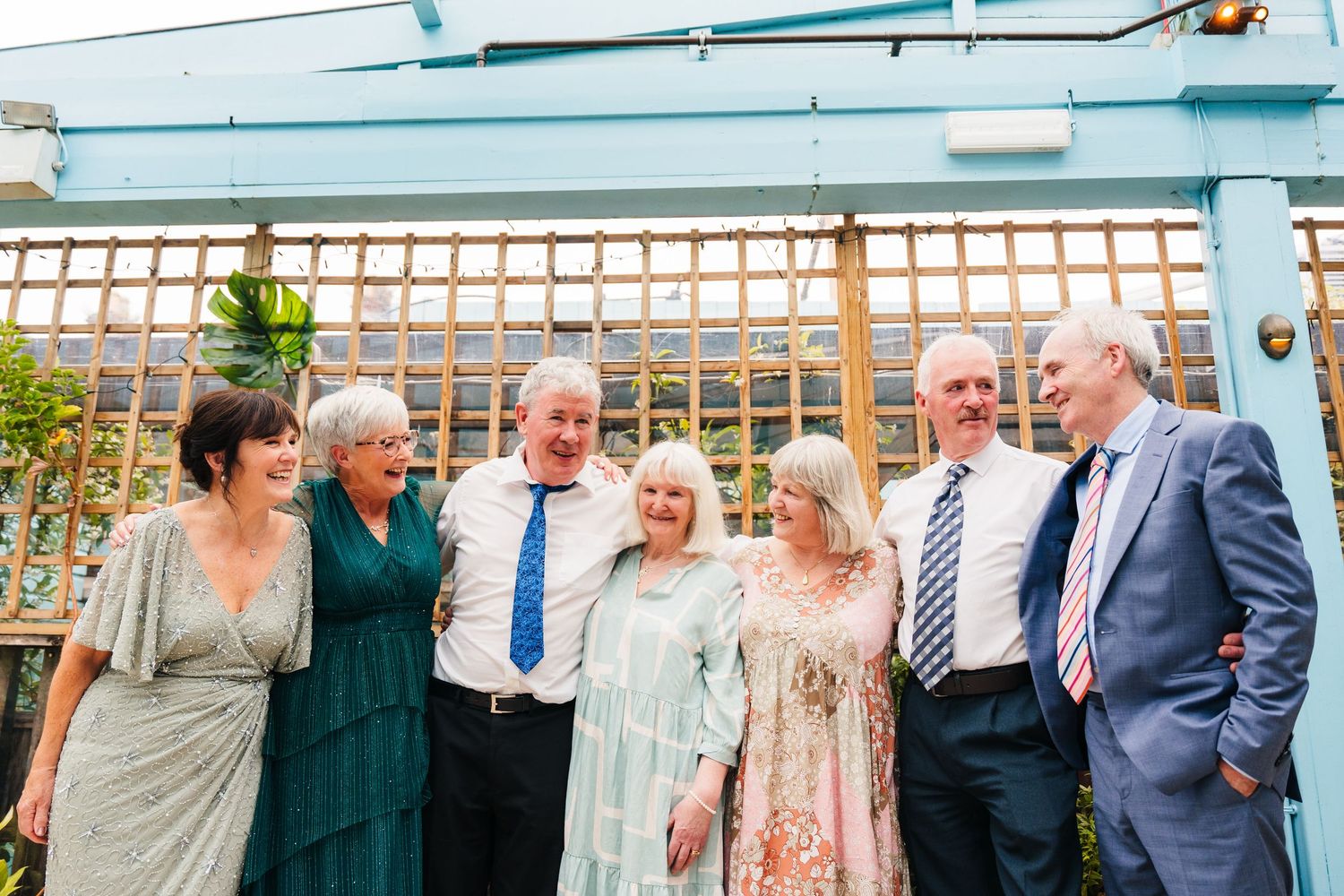 Group gathered at an outdoor venue with lattice backdrop celebrating a special occasion together. House Dublin Wedding Photographer