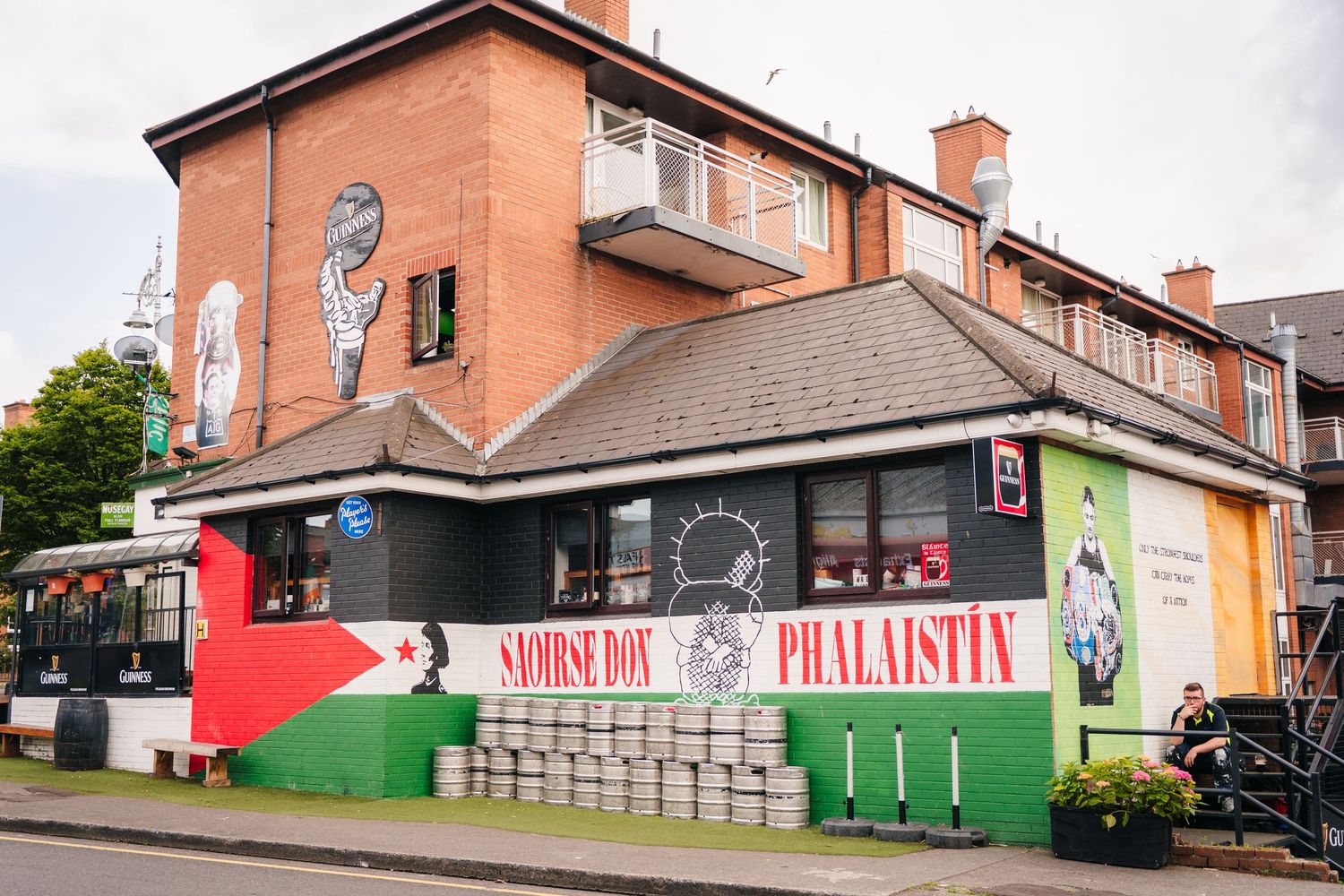 A colorful mural-decorated corner shop with Palestinian flags and artwork on its exterior. Same sex wedding PHOTOGRAPHER Dublin