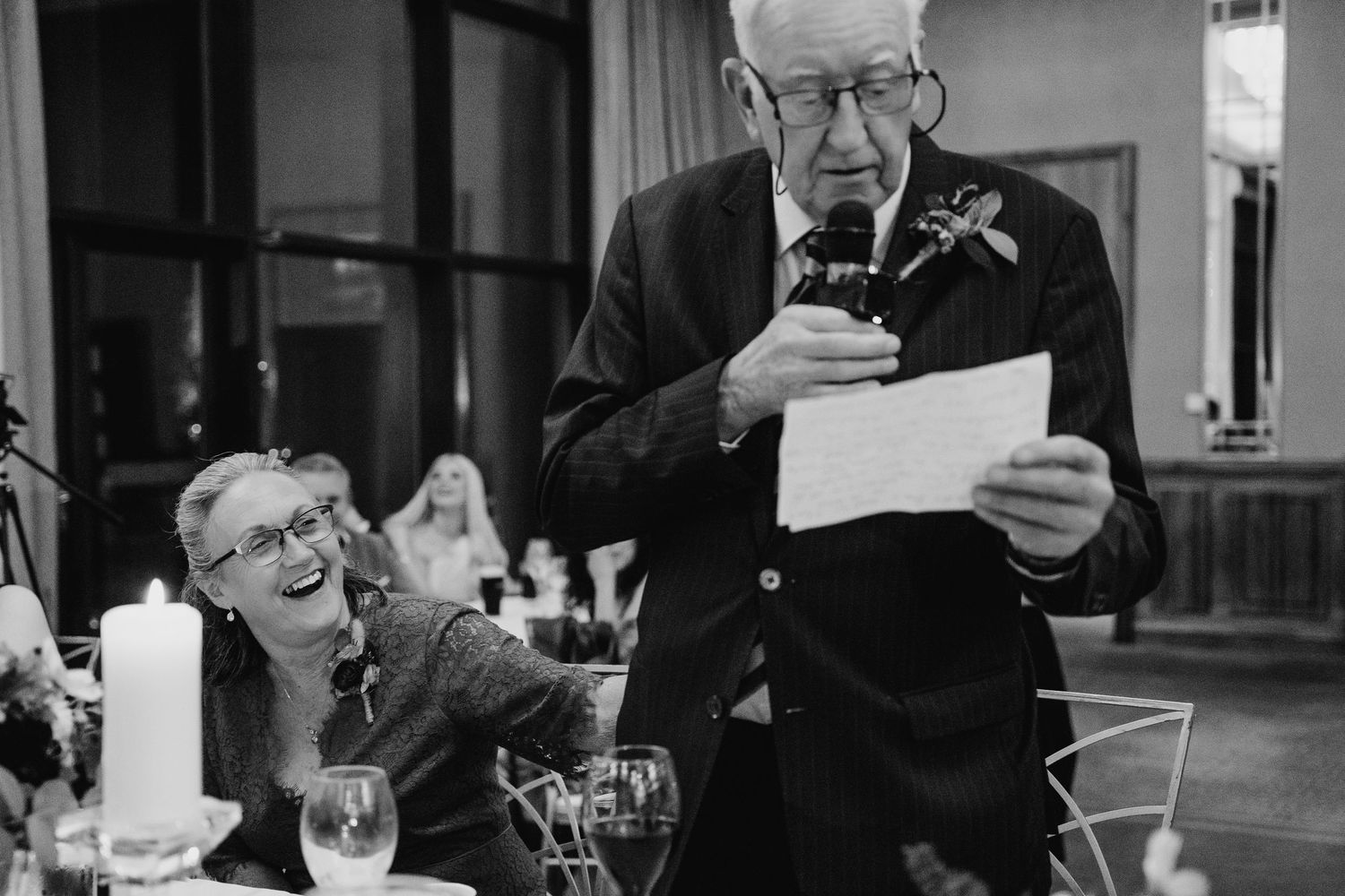 Wedding guest delivers speech while reading from paper at reception dinner.Wedding Photography Trim Castle Ireland