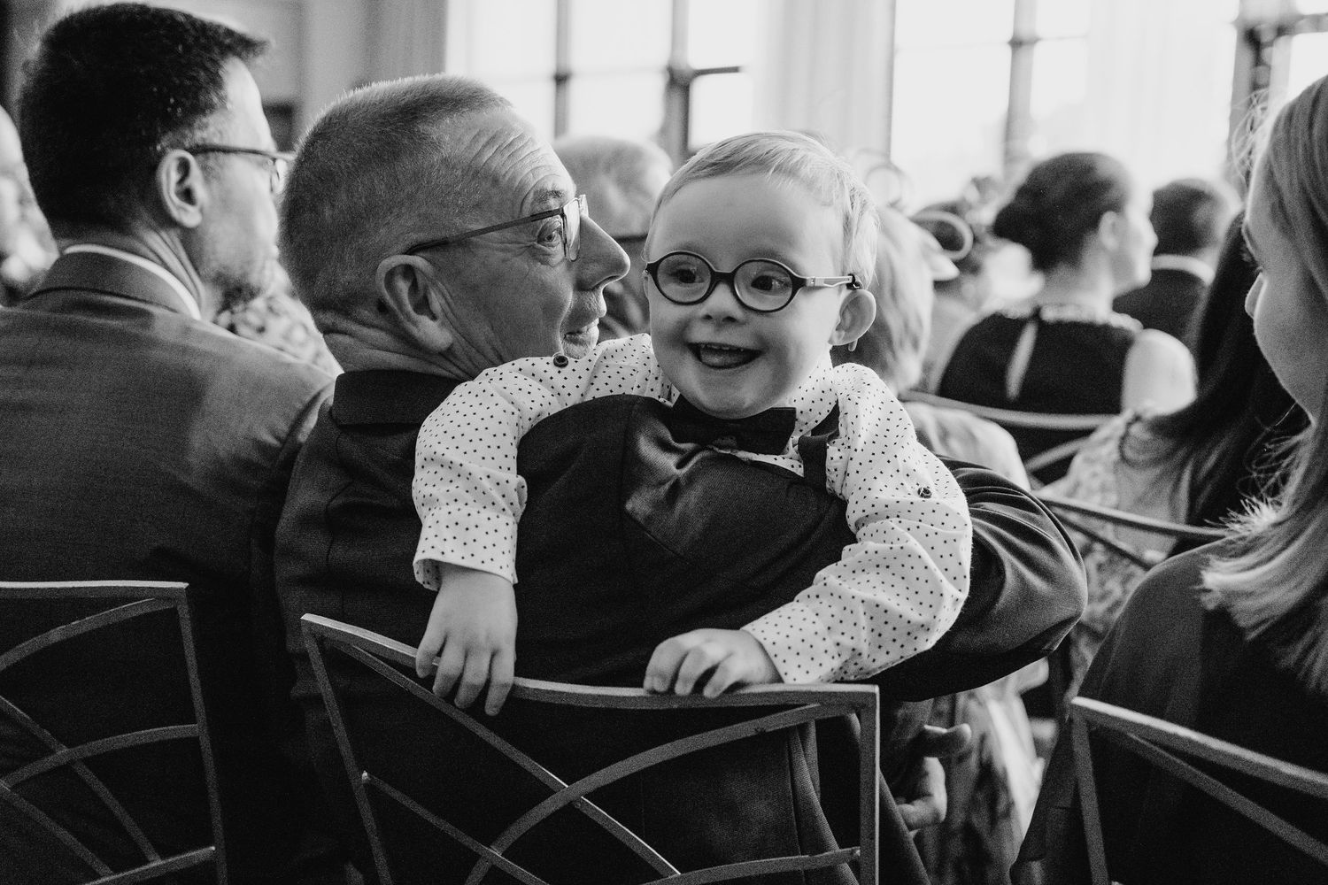 Black and white photograph of wedding guests seated in chairs during ceremony. Wedding Photography Trim Castle Ireland