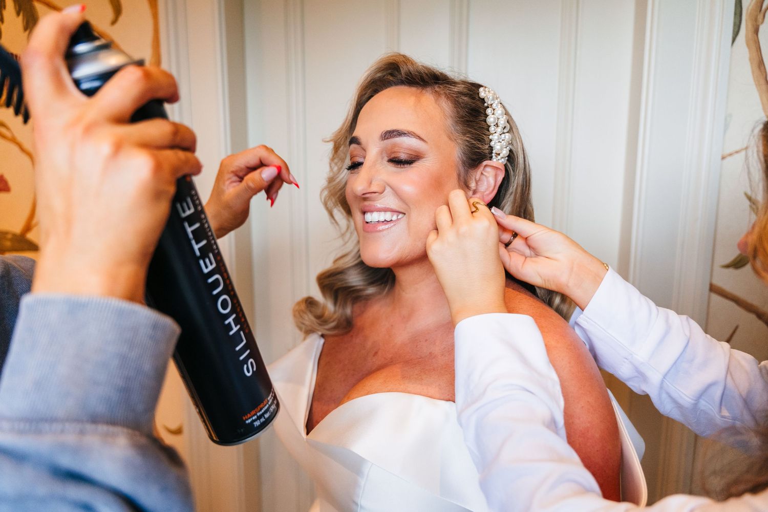 Wedding preparation scene with bride getting hair and makeup done by stylists. Virginia Park Lodge Wedding Photographer Dublin Meath Ireland