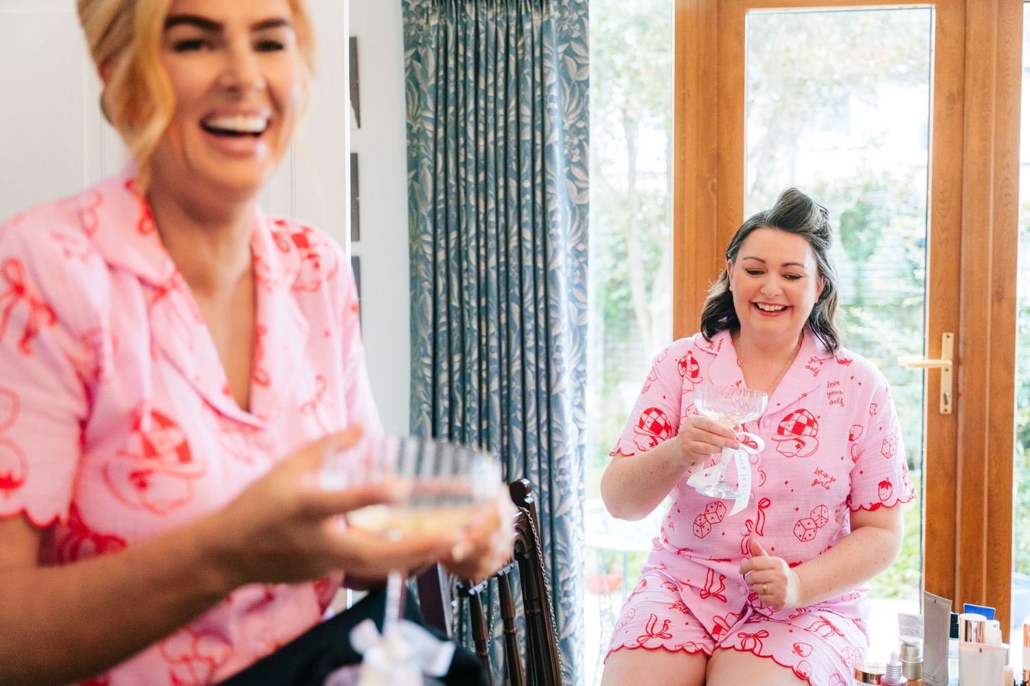 People in matching pink floral robes share joyful moments during a wedding prep celebration. The Dean Dublin Wedding Photographer