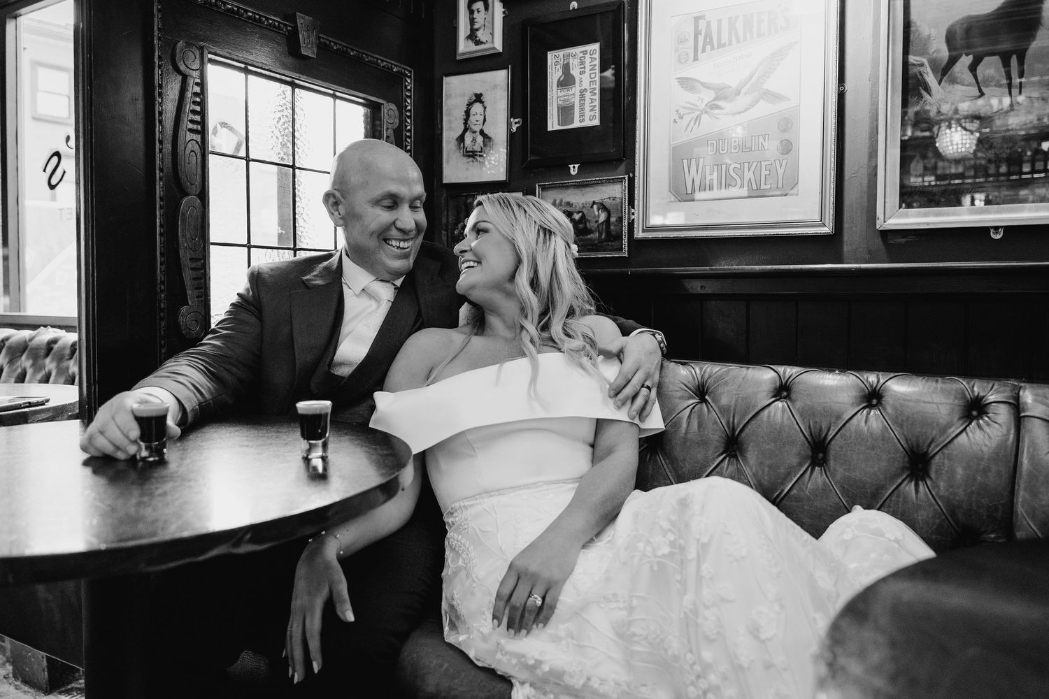 A couple shares an intimate moment in a cozy pub setting with vintage decor. The Dean Dublin Wedding Photographer