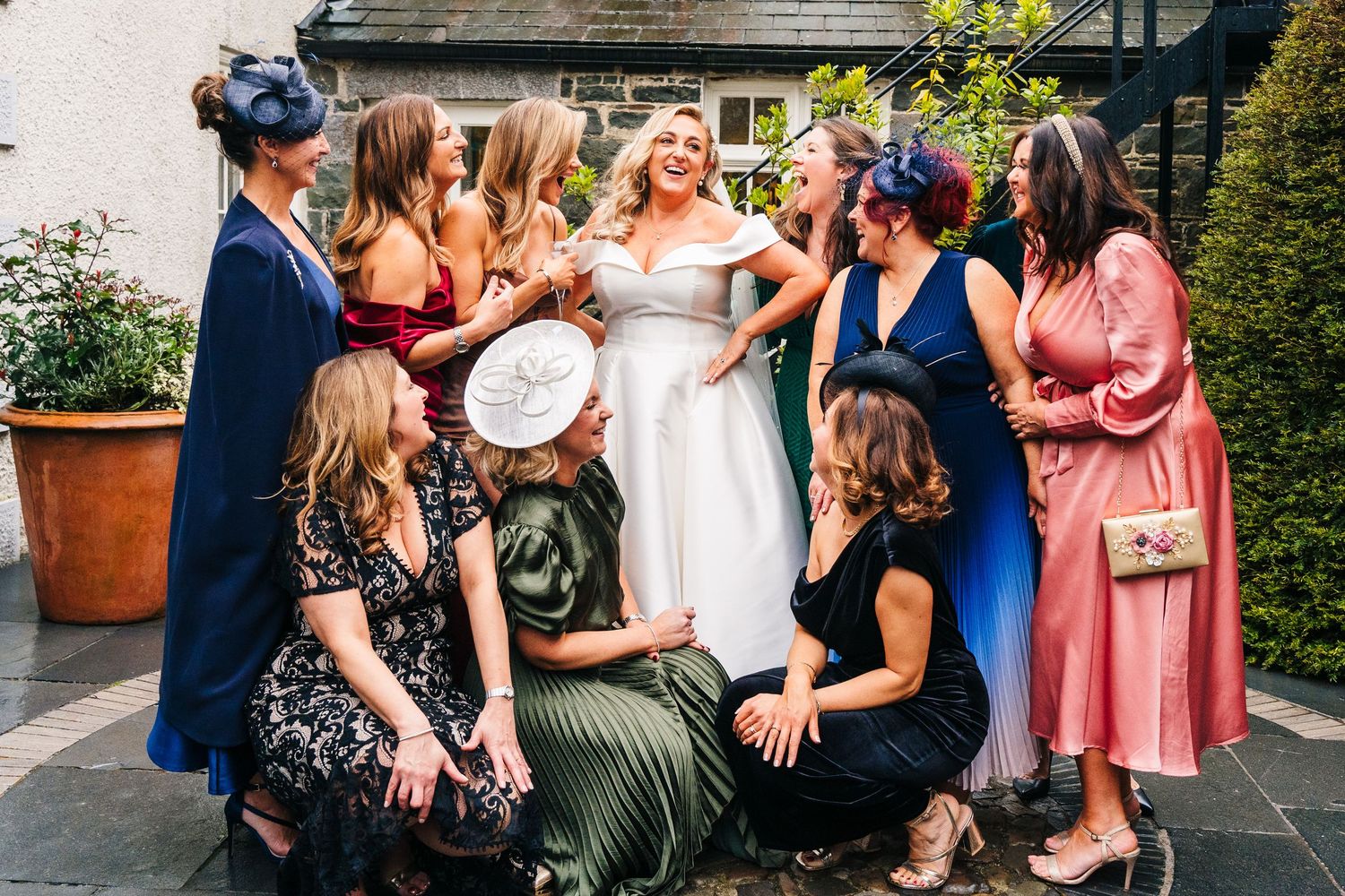 A joyful moment captured at a wedding celebration with colorful dresses and laughter among a group celebrating outdoors. Wedding PHOTOGRAPHE