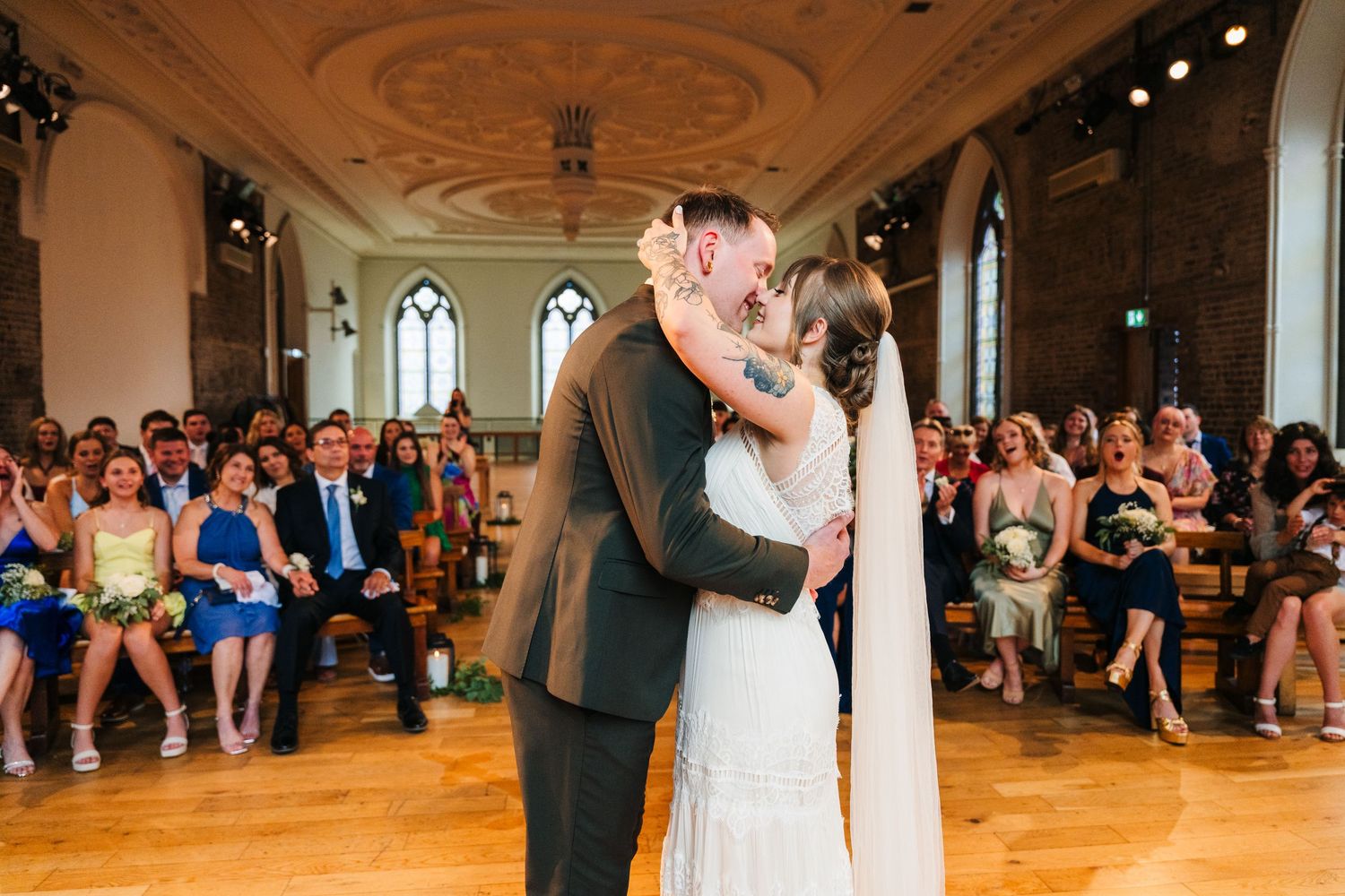 A first dance in a grand ballroom with ornate ceiling details as guests watch from the sides. Wedding PHOTOGRAPHER Dublin