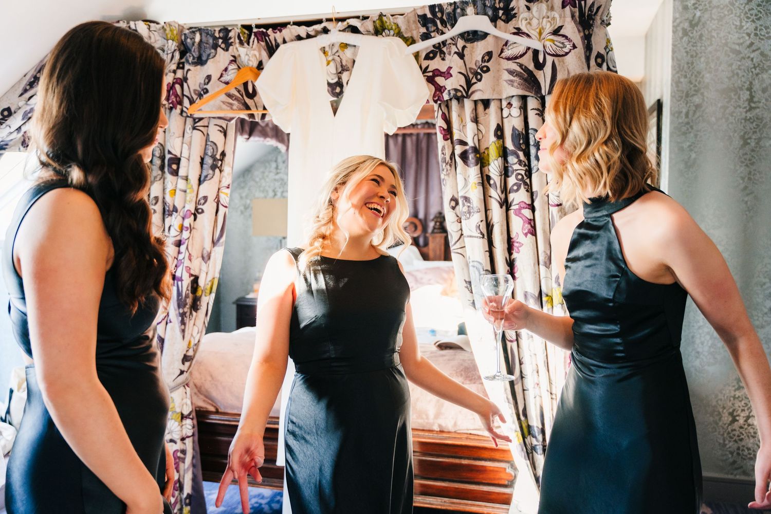 Three women in navy blue dresses share a joyful moment together at what appears to be a wedding preparation. City Hall Dublin Photographer