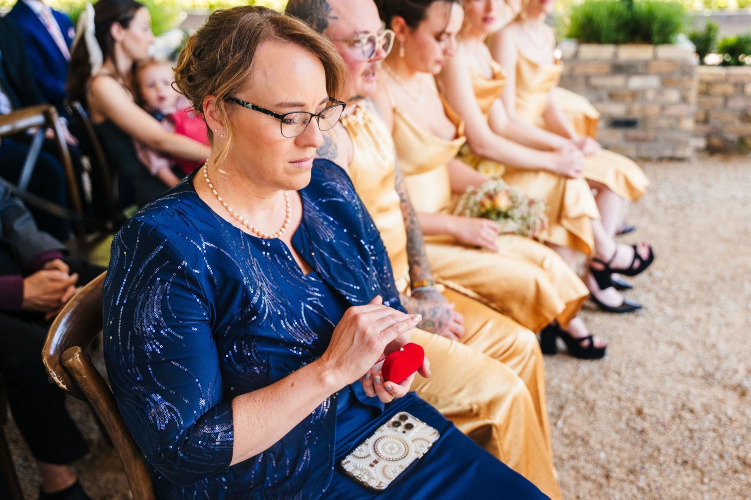 Poulaphouca Wedding photographer wicklow  Person in blue dress holding a red phone case during an outdoor event.