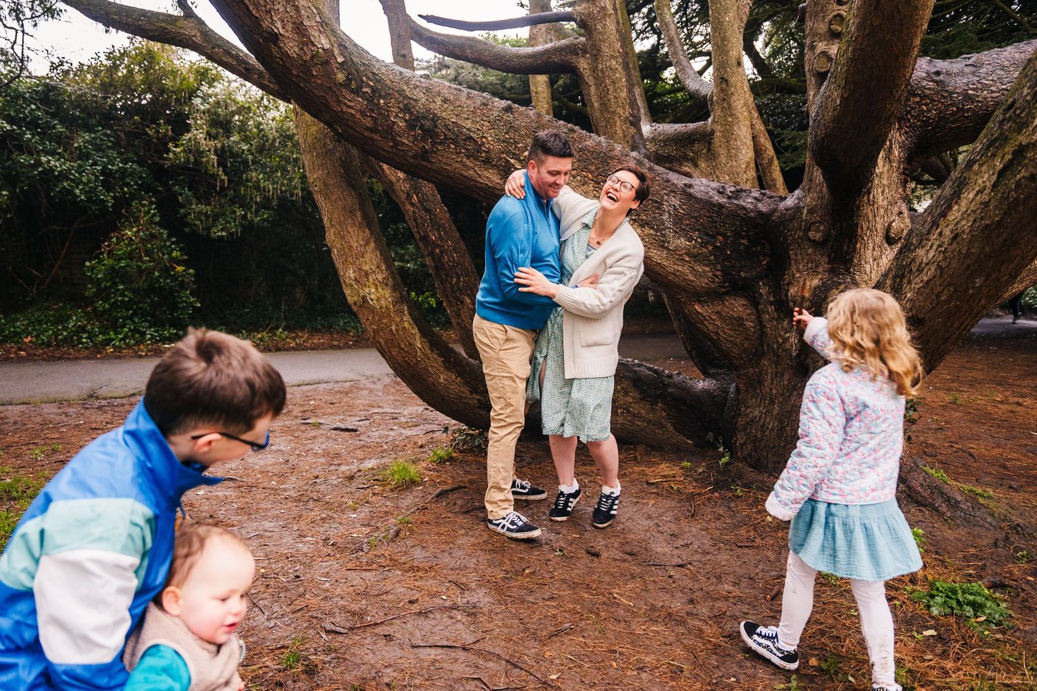 Couple dancing beneath winding branches of a majestic live oak tree in a romantic garden setting. Family photographer Dublin Ireland