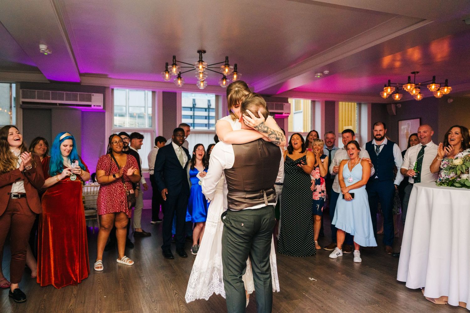 Wedding couple embraces during their first dance while guests watch from the perimeter. PHOTOGRAPHER Dublin Ireland Wedding