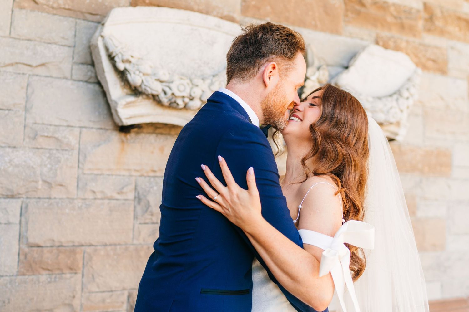 Castle Leslie Wedding Photographer Dublin Romantic wedding couple sharing intimate moments against a stone wall backdrop.