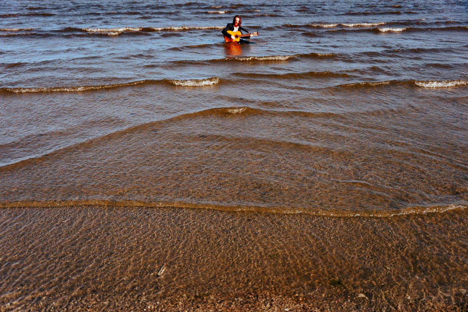 Dark rippling waters of the ocean with waves breaking gently on the sandy shore. PHOTOGRAPHER Dublin