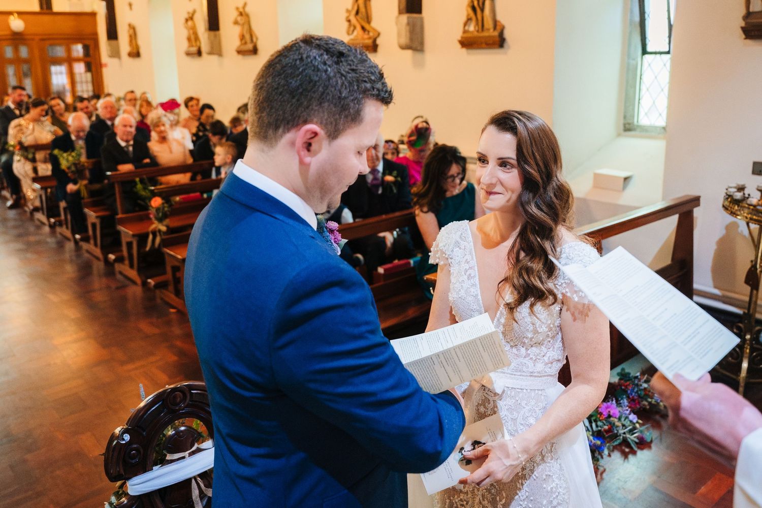 Traditional church wedding ceremony with ornate religious statues and decorative elements.