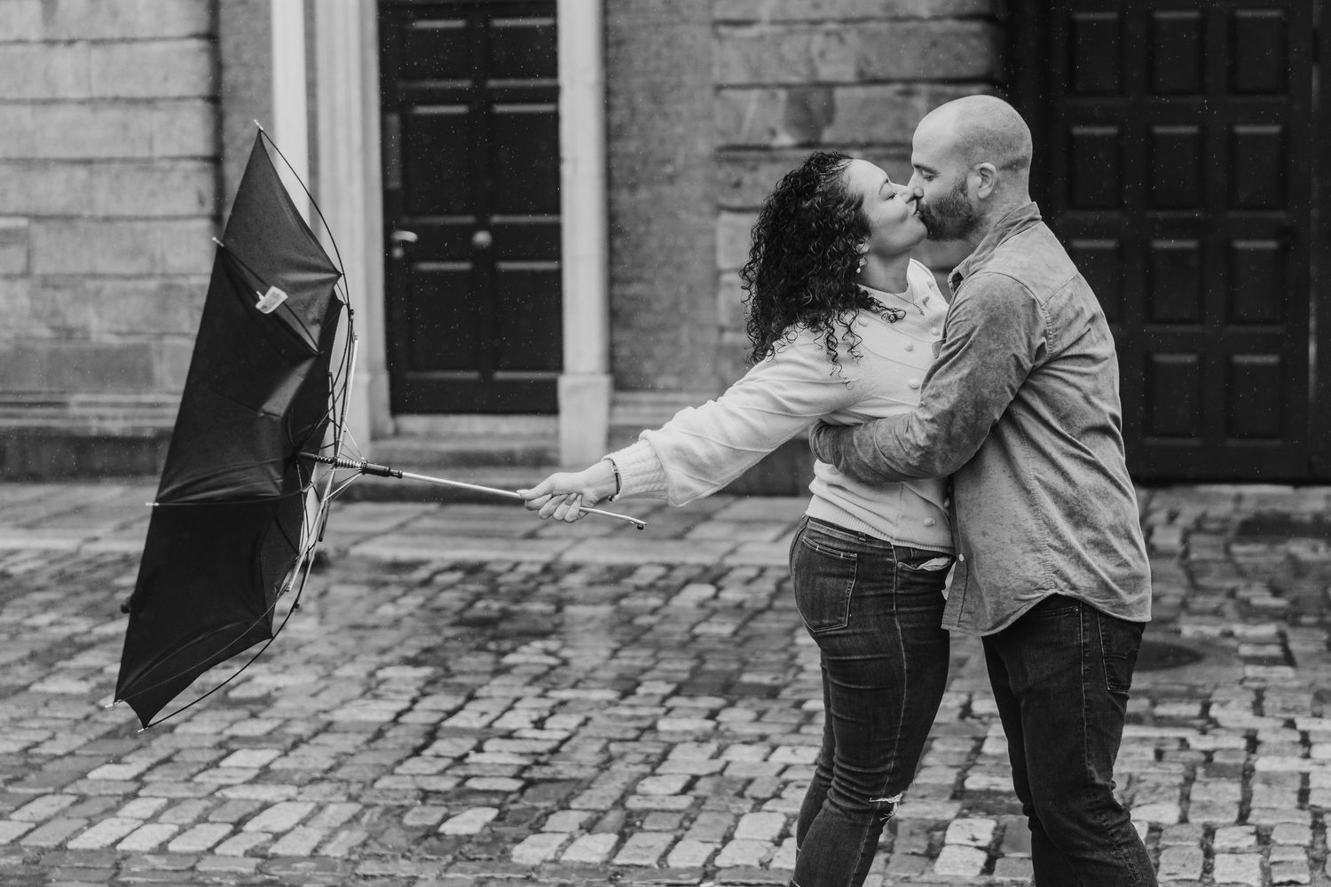 A couple dancing on a cobblestone street in black and white showing graceful movement and romantic connection. PHOTOGRAPHER DUBLIN IRELAND