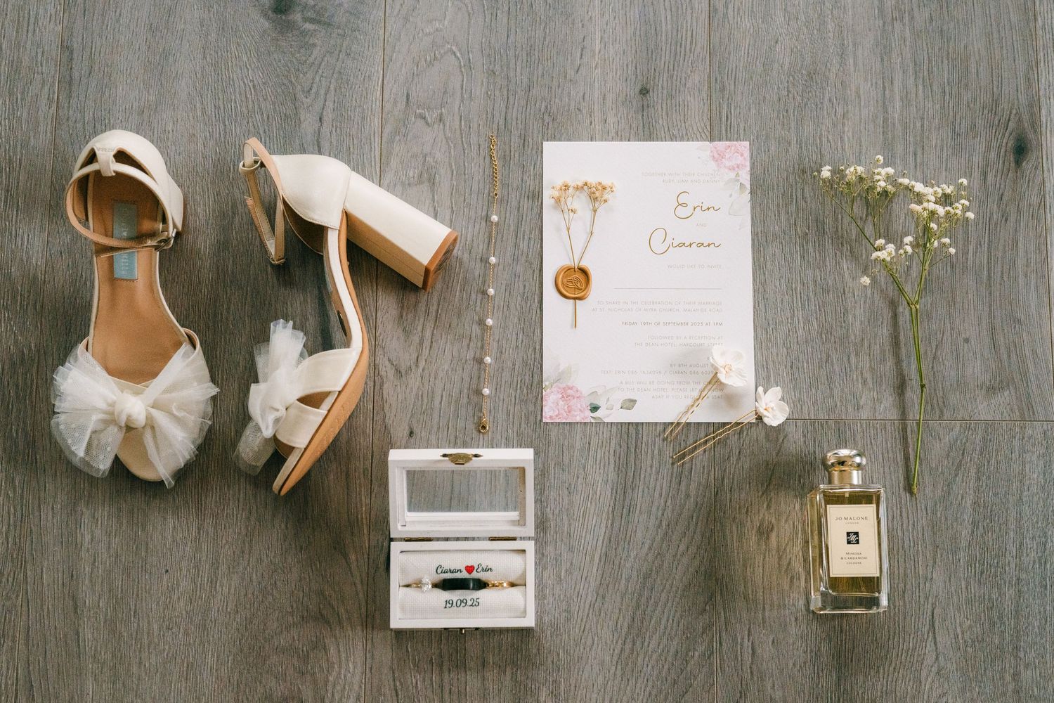 Wedding accessories and details arranged in a flatlay on a rustic grey wooden background. The Dean Dublin Wedding Photographer