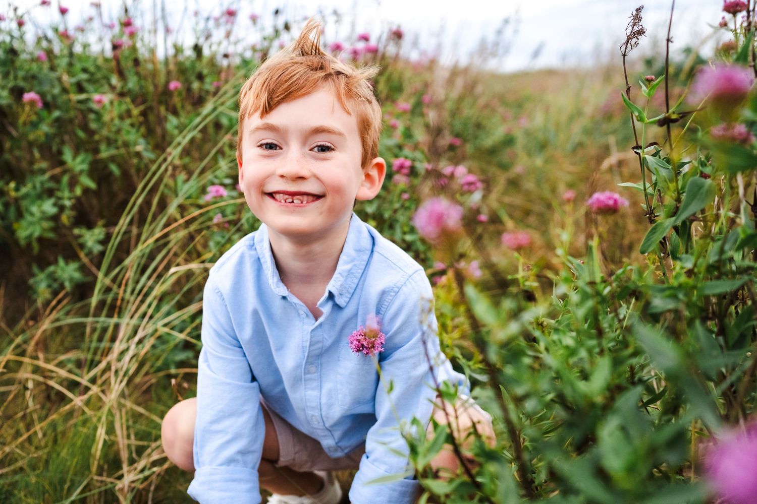 Natural family portraits among blooming wildflowers on coastal dunes.  Family photographer Dublin Ireland