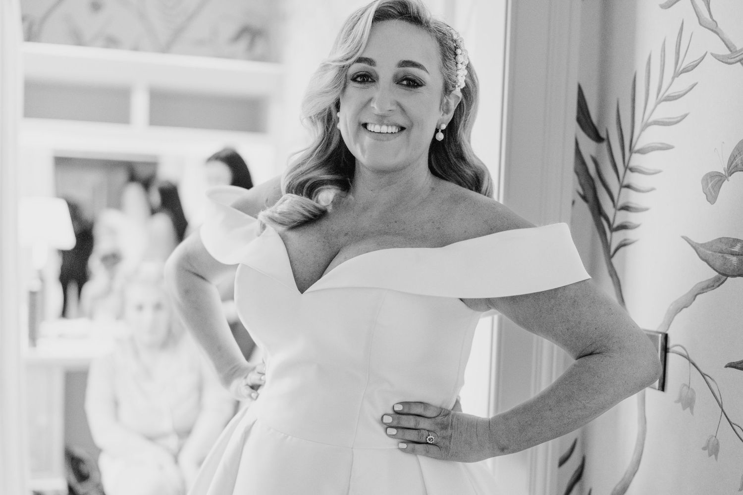 Black and white photo of someone in an elegant off-shoulder white wedding dress smiling at the camera. Virginia Park Lodge Wedding Photograp