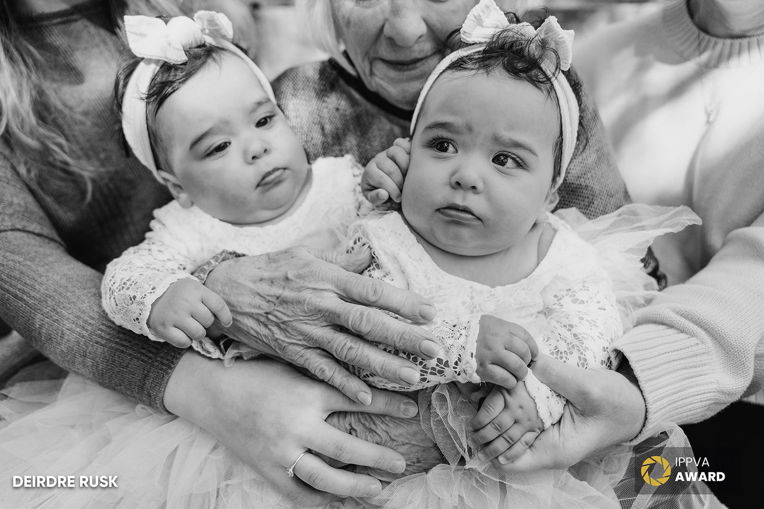 Black and white portrait of twin babies in matching white dresses and headbands. PHOTOGRAPHER Dublin Ireland meath