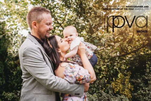 Sweet family moment captured outdoors with natural sunlight filtering through trees. Family PHOTOGRAPHER Dublin