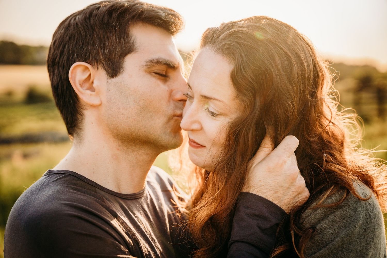 Romantic couple sharing tender moments in golden sunlight during sunset photo session. PHOTOGRAPHER Dublin ireland