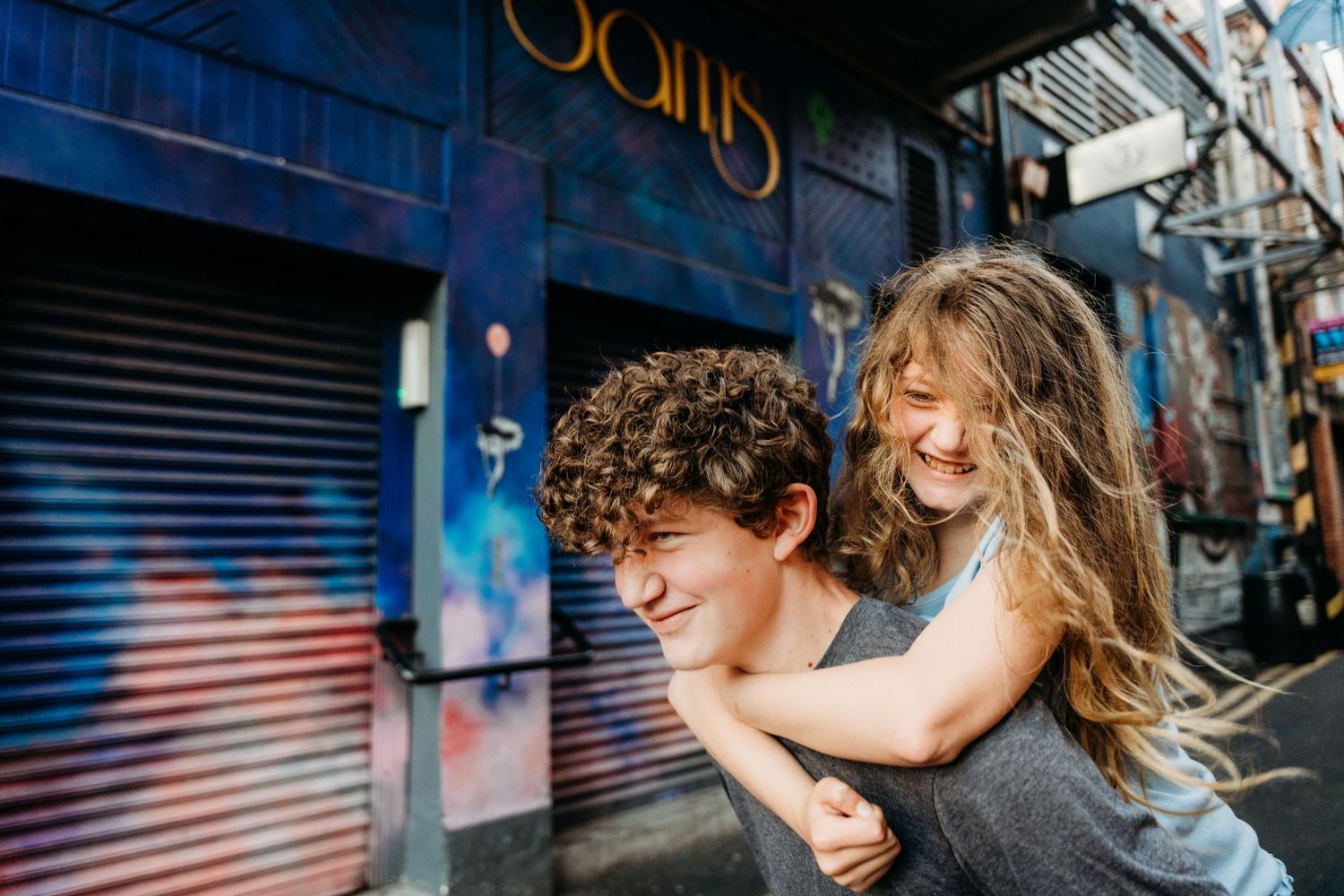 A captivating urban dance performance sequence showing fluid movements against a city backdrop with metal shutters. family PHOTOGRAPHER Dubl