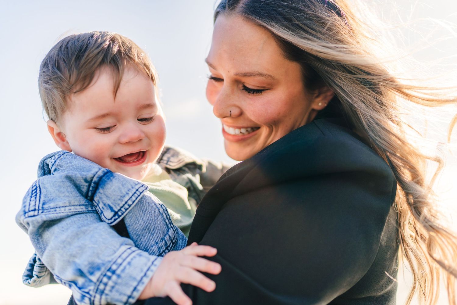 Mother and child share joyful smiles and laughter while playing together outdoors. family PHOTOGRAPHER Dublin