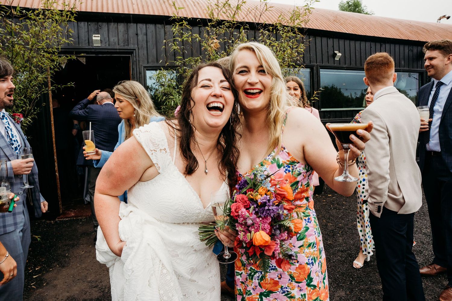 Wedding guests sharing laughs and embraces during an outdoor celebration. Wedding photographer Dublin