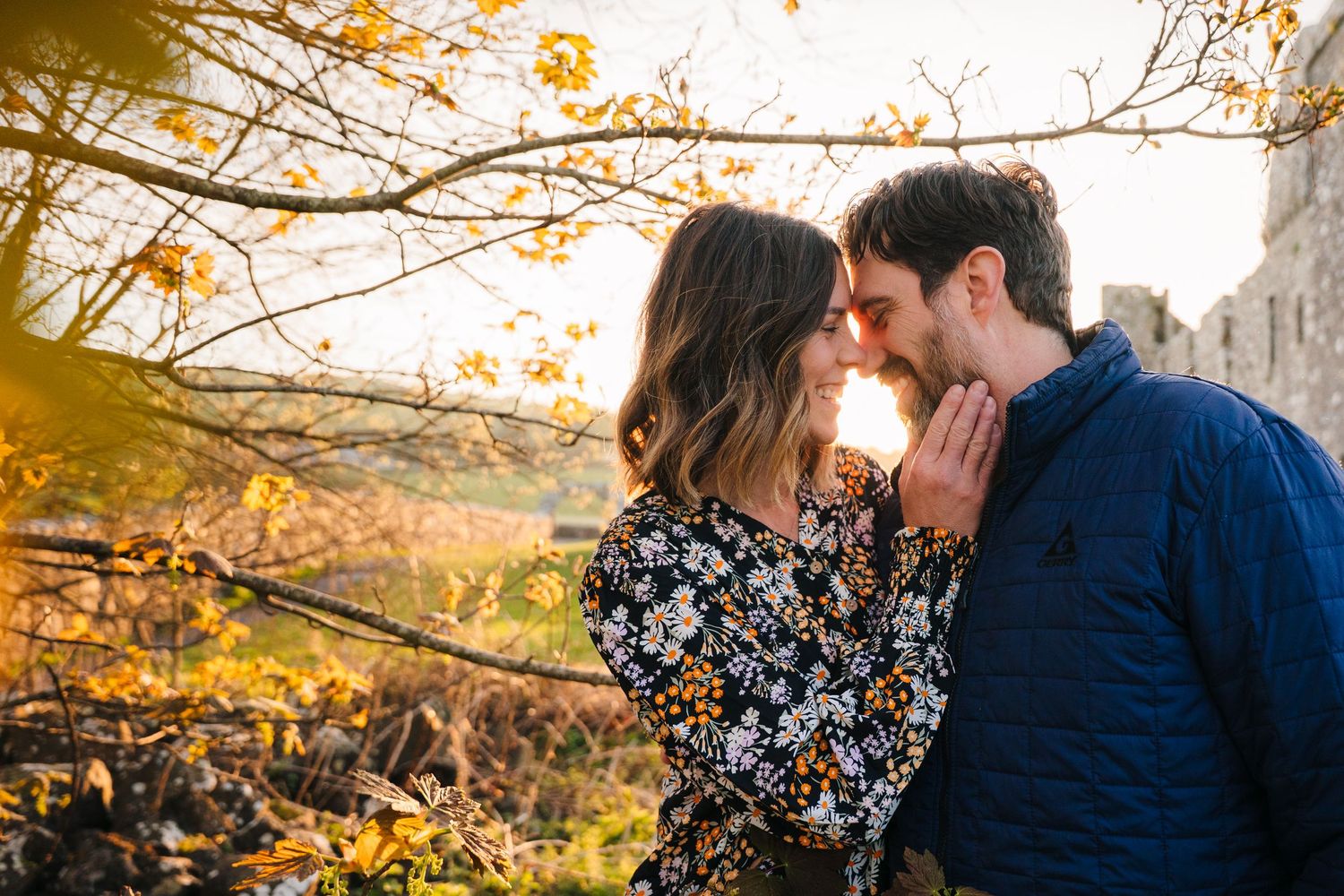 Golden hour photoshoot under tree branches near historic stone ruins. Photographer Ireland dublin