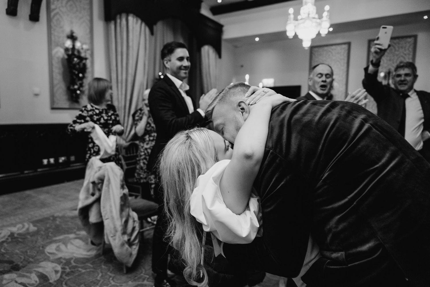 Lively wedding reception dance scene in black and white at an elegant indoor venue with chandelier lighting. City Hall Dublin Photographer