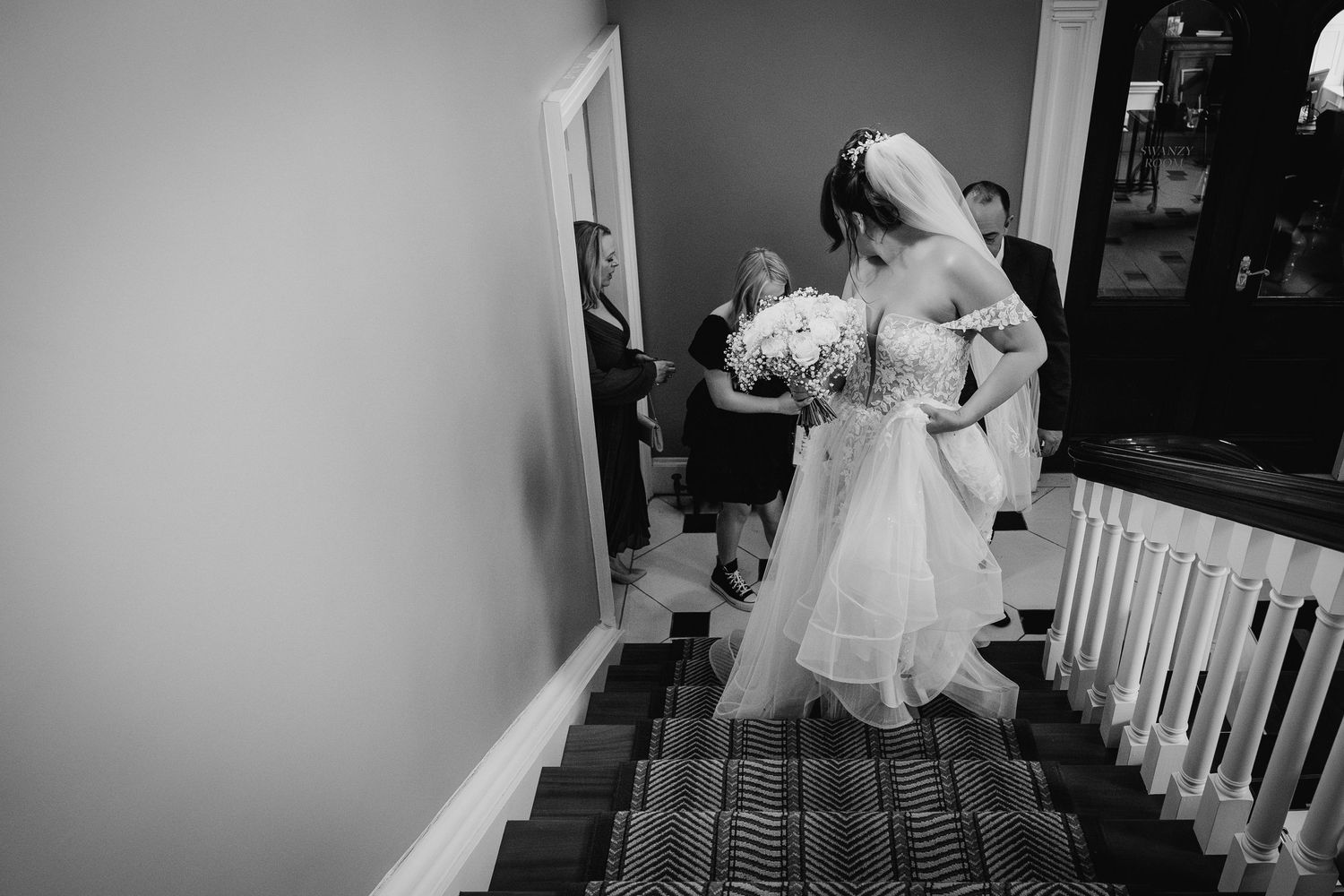 Elegant wedding couple descends carpeted staircase in a dramatic black and white photograph.  Wedding PHOTOGRAPHER Dublin